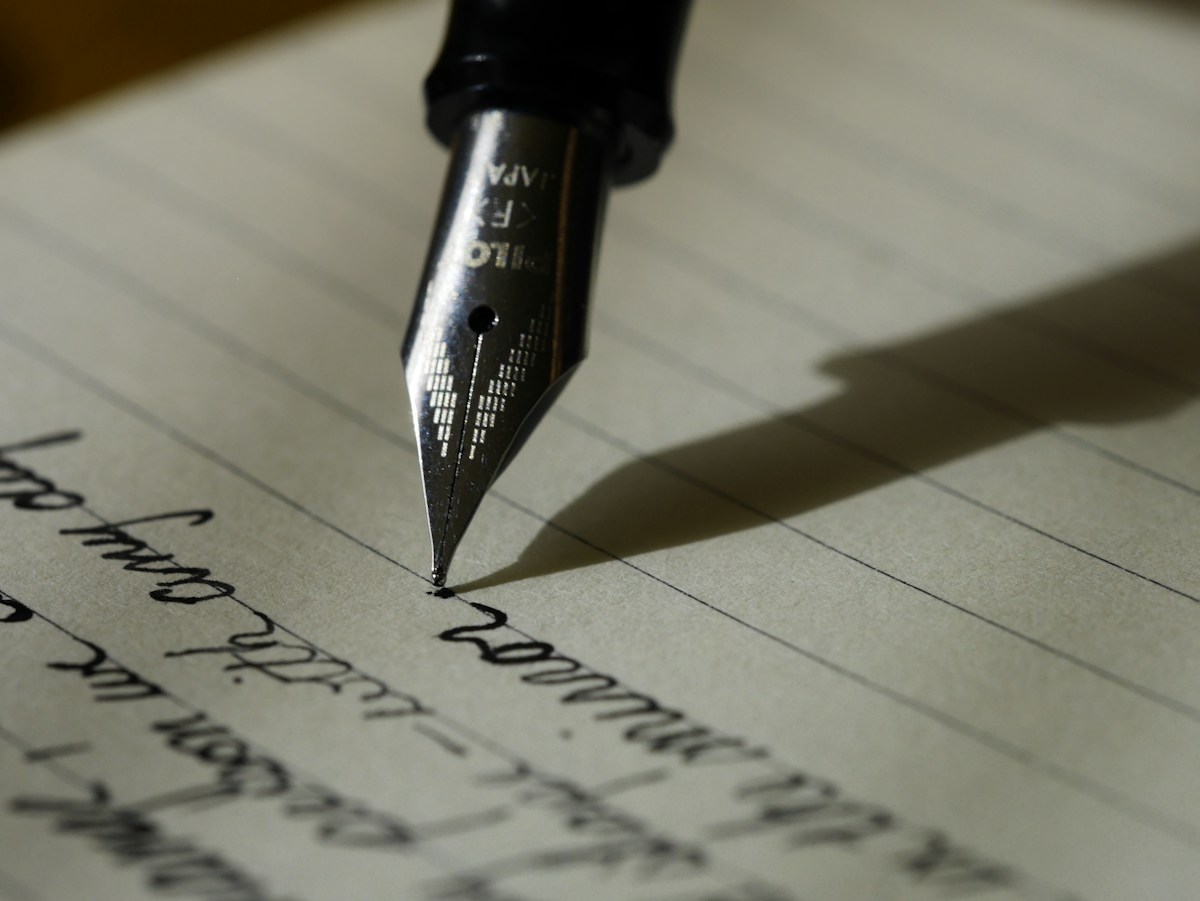 Close-up of a fountain pen writing on a manuscript